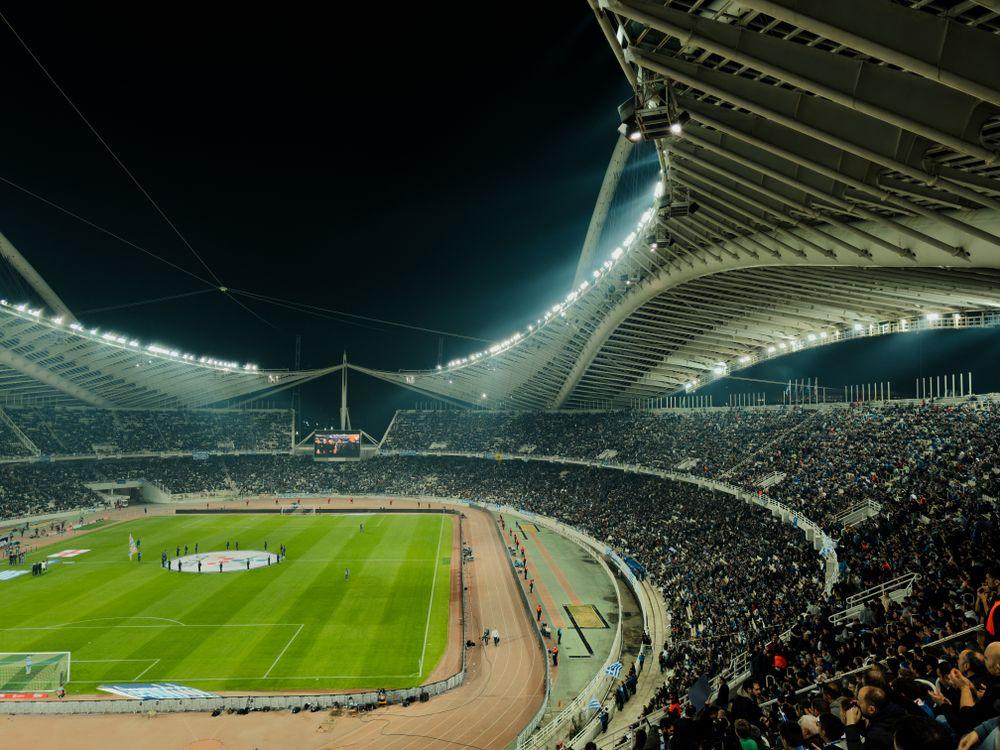 Stadion sepak bola penuh penonton di malam hari menggambarkan cashback sportsbook